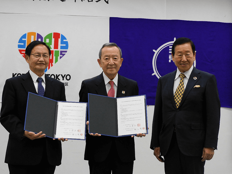 〈締結式の様子〉左から、陶山学長、山﨑区長、小林理事長